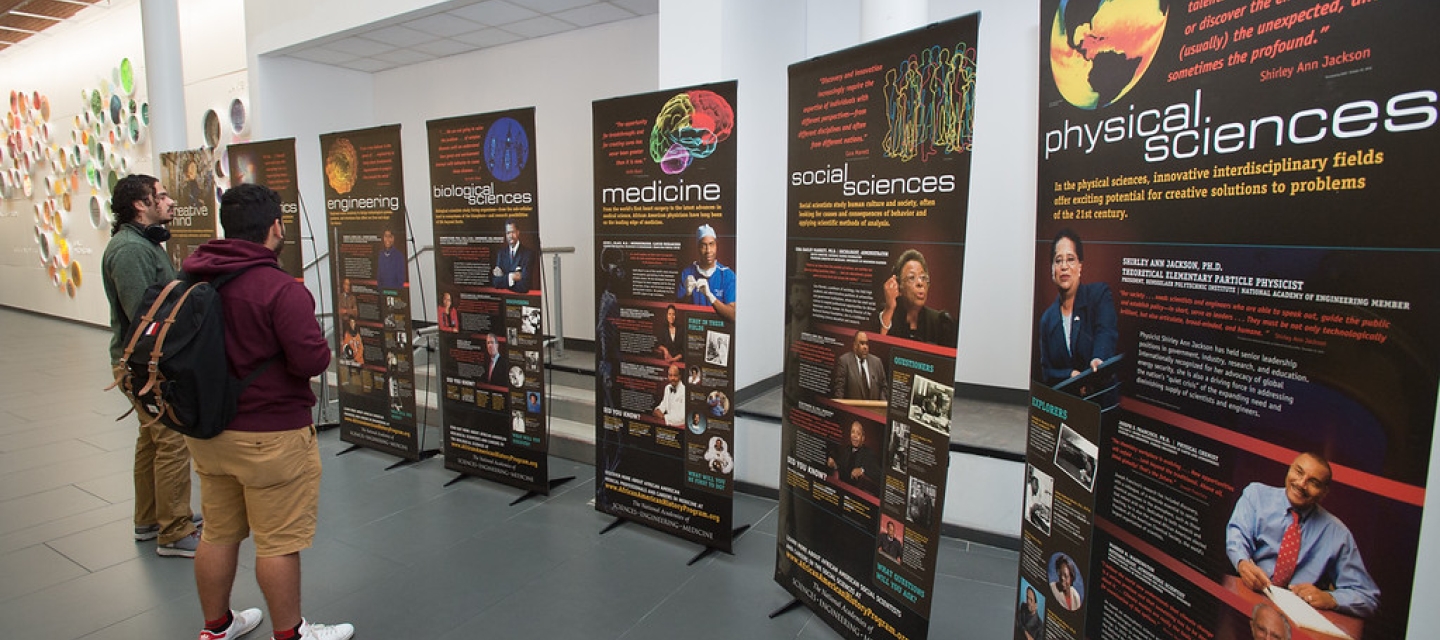 Students looking at African American Science History display in Science Building Atrium at Buffalo State College.